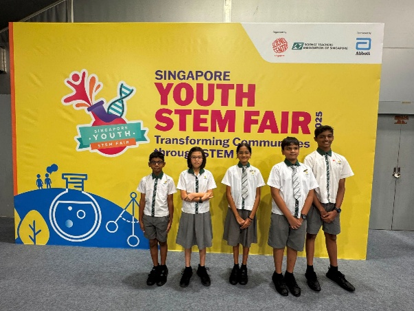 Students posing at the Singapore Youth STEM Fair event backdrop.